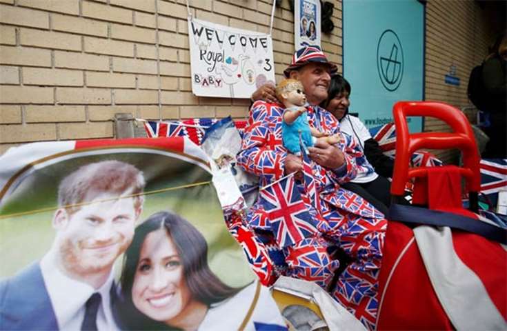 A royal supporter sits outside St Mary\'s Hospital after the Duchess of Cambridge was admitted