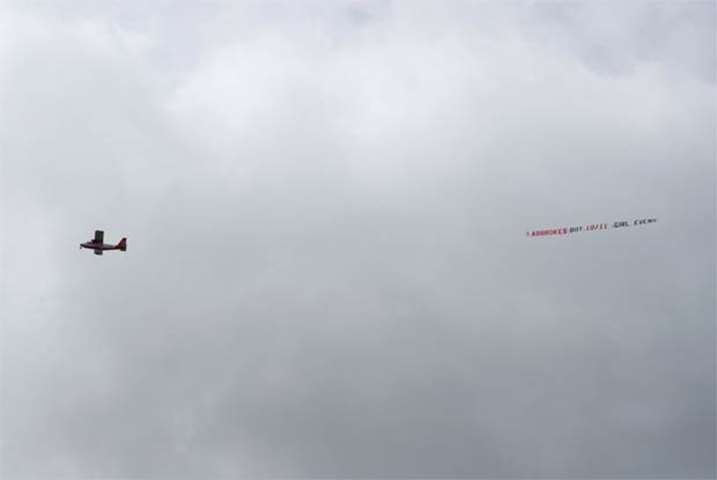 An airplane towing an advertisement for a bookmakers flies over the Lindo Wing of St Mary\'s Hospital