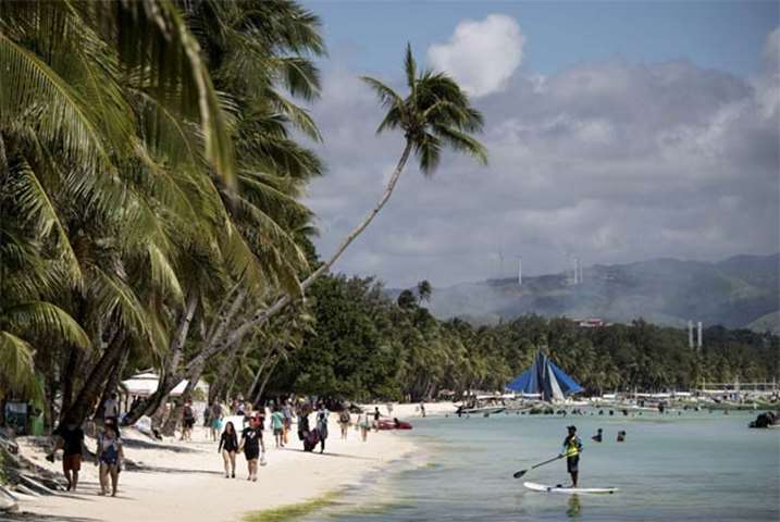 Tourists are seen at the white sand beach of Boracay on Tuesday