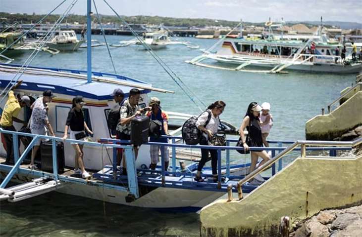 Tourists leave after vacationing on Boracay on Tuesday ahead of its closure