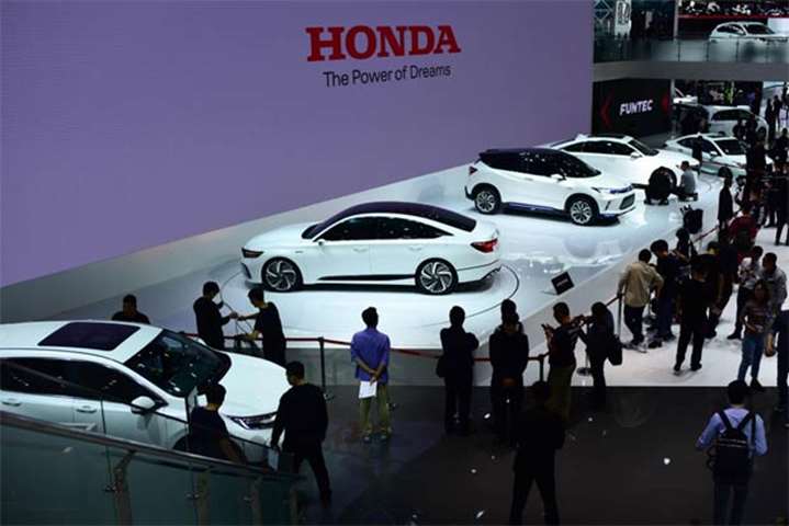 People visit the Honda booth at the Beijing auto show on Wednesday