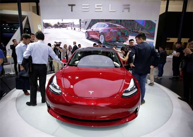 Visitors check a Tesla Model 3 car at the Beijing show