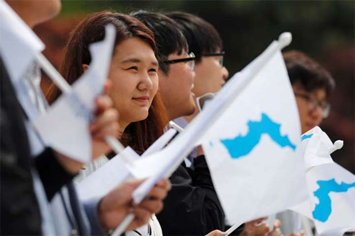 Students hold Korean unification flags during a pro-unification rally in Seoul on Thursday