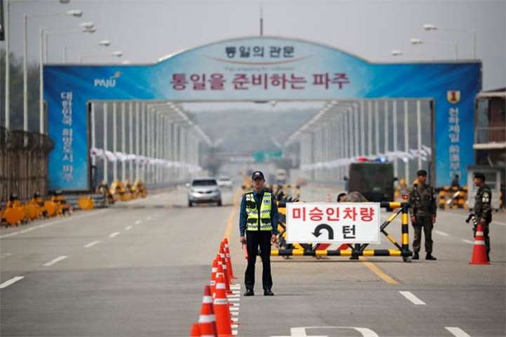 A policeman stands guard at a checkpoint on the Grand Unification Bridge