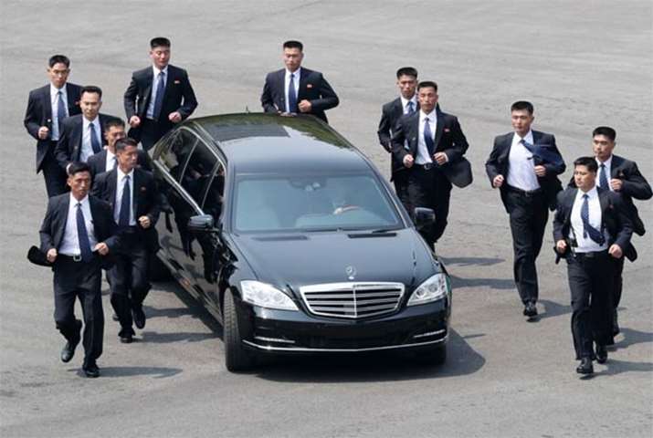 North Korean bodyguards jog next to a car carrying Kim Jong Un