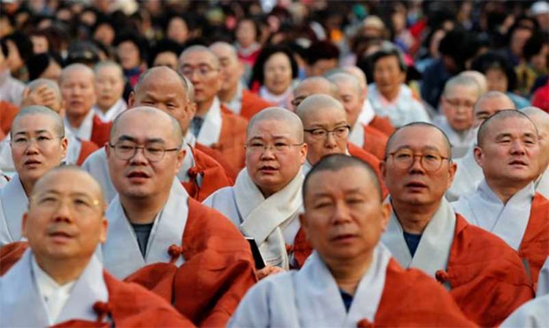 Buddhist monks and nuns look on during a prayer service in Seoul wishing for a successful summit