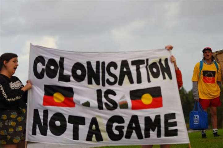 Australia\'s Aboriginal activists hold a banner during a protest outside the Carrara Stadium