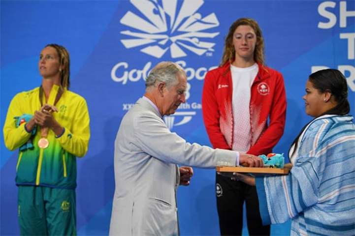 Prince Charles gives the gold medal to Canada\'s Taylor Ruck (right) after the 200m freestyle final