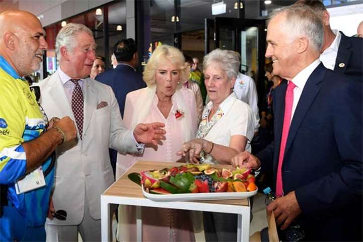 Prince Charles and Camilla taste fruit available to athletes as Malcolm Turnbull looks on