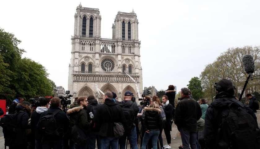 Journalists work in front of Notre-Dame Cathedral