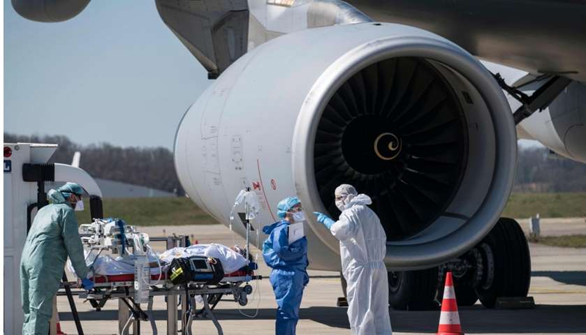 Medical staff embark a patient infected with the COVID-19 onboard Airbus A330 Phenix aircraft