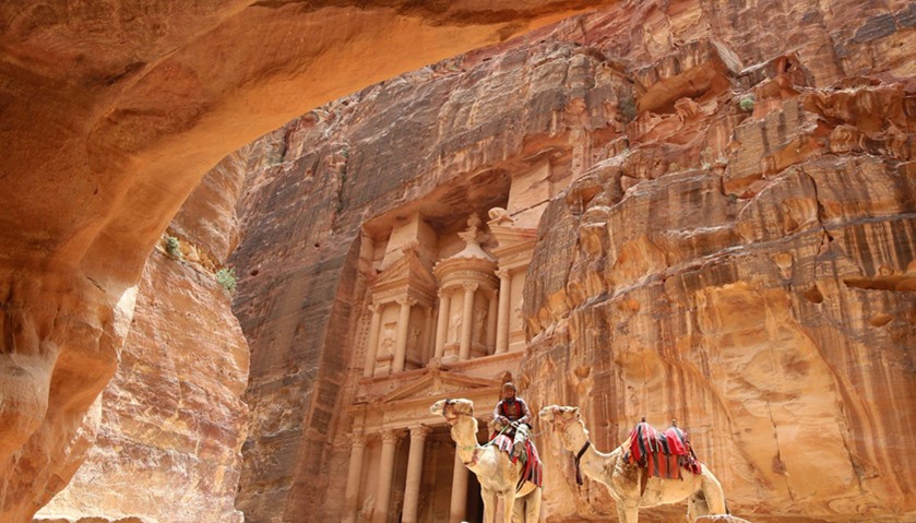 A Jordanian Bedouin sits on a camel in front of the Treasury Building in the ancient city of Petra i