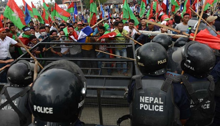 Activists confront police as they try to break through a police cordon in Kathmandu on Monday