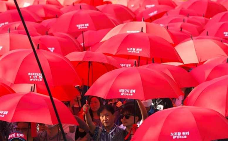 South Korean unionised workers carry red umbrellas during a May Day rally in Seoul on Monday