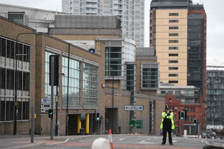 A police officer stands guard by Manchester Arena in Manchester on Tuesday