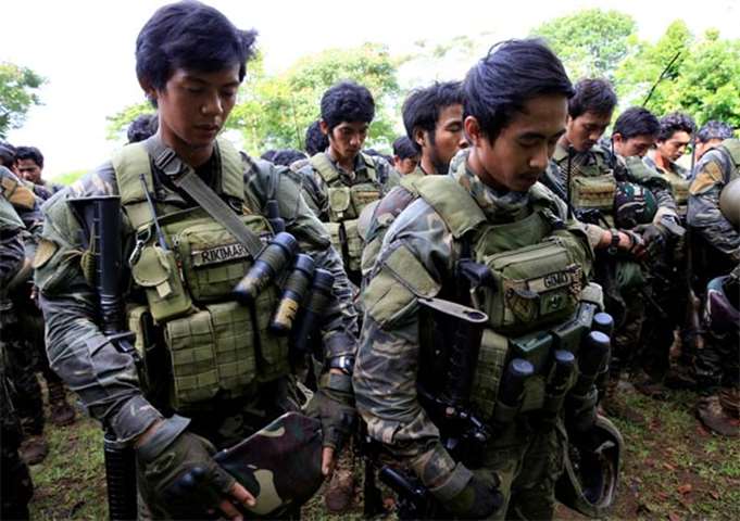 Troops pray before their assault with insurgents from the so-called Maute group