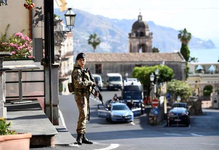A military guard stands watch at the G7 summit in Taormina, Italy on Friday