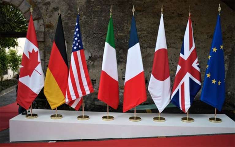 The flags of seven participating countries and European Union stand in front of the summit venue