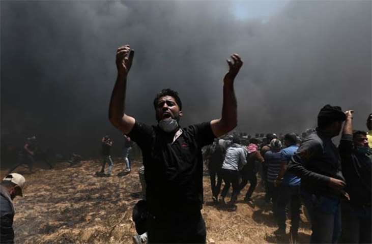 A Palestinian demonstrator shouts during a protest at the Israel-Gaza border in Gaza Strip on Monday