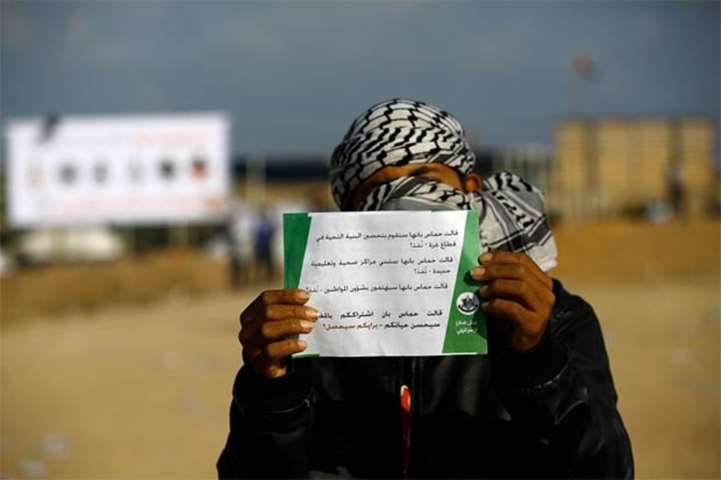 A Palestinian boy holds a leaflet dropped by the Israel military, east of Gaza City on Monday