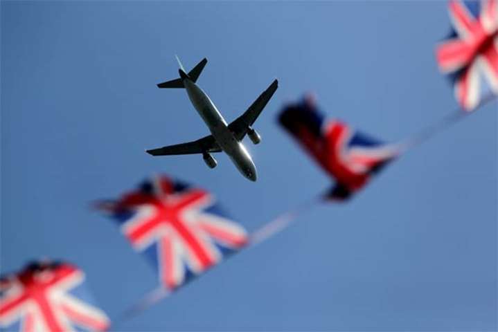 An aeroplane flies over Windsor Castle in Windsor on Thursday