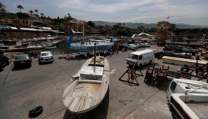 Activists build a boat from plastic water bottles at the ancient port of the Lebanese coastal city o