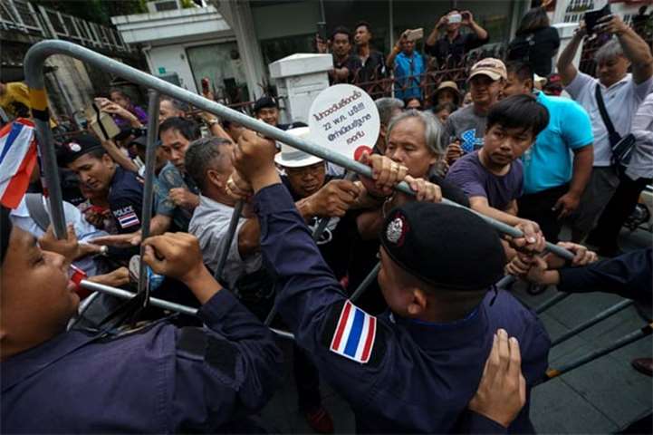 Anti-government protesters confront riot police officers in Bangkok on Tuesday