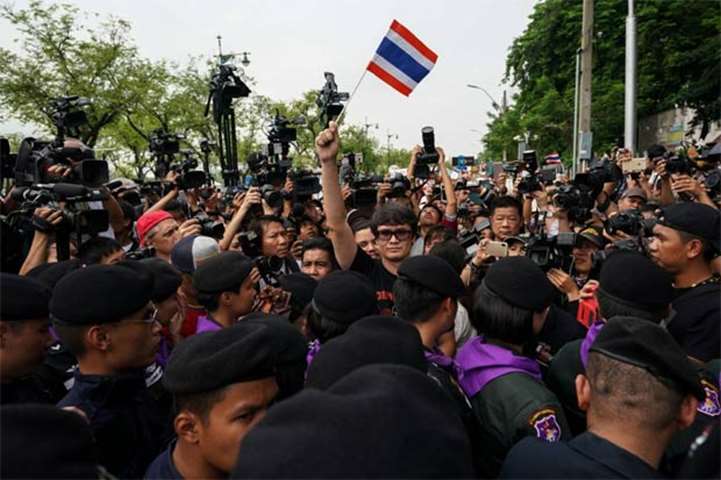 Pro-democracy activist Rome Rangsiman holds up a Thailand flag during a protest in Bangkok