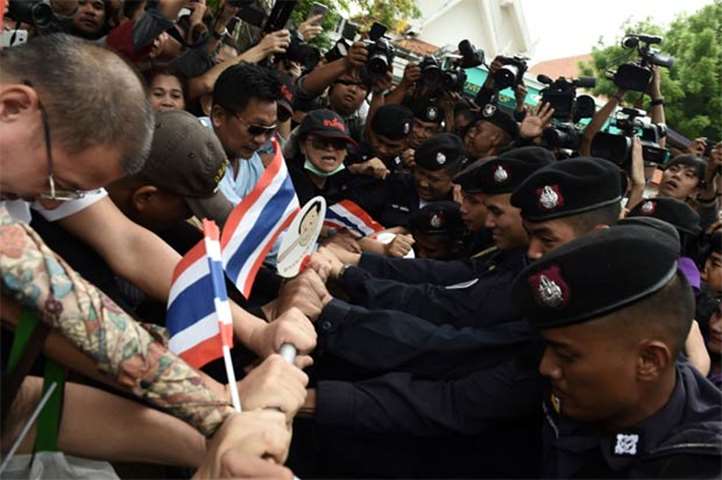 Activists try to break through a police cordon during a protest to mark fourth year of junta rule