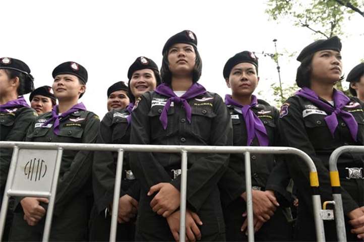 Thai policewomen stand behind a police barricade outside Thammasat University in Bangkok