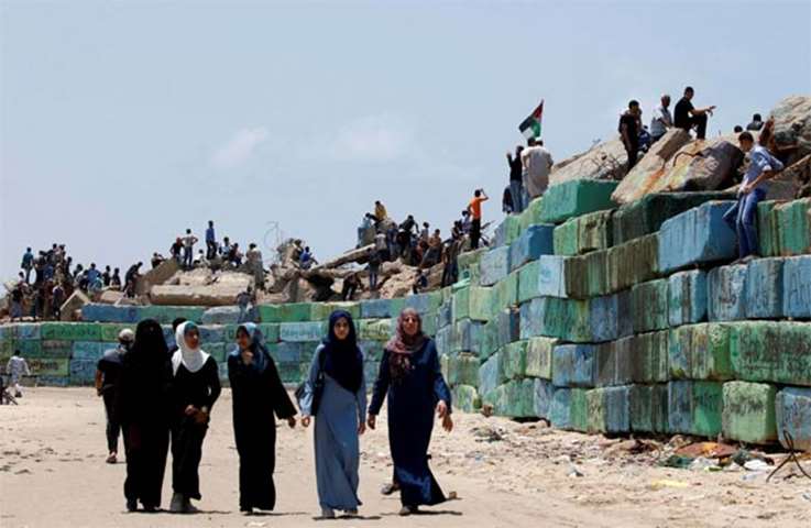 People gather as Palestinians prepare to sail a boat towards Europe aiming to break the blockade