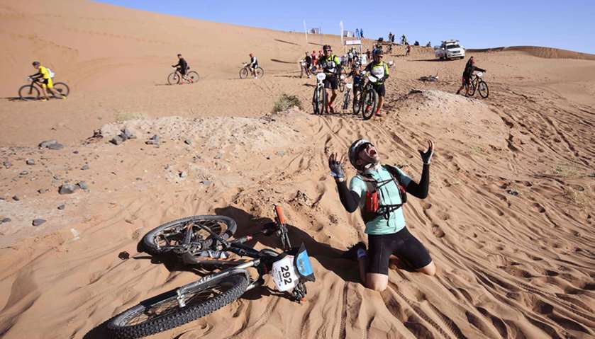 A competitor reacts after crossing a sand dune during Stage 4 of the 13th edition of the Titan Deser