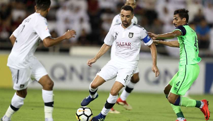 Al-Sadd\'s captain Xavi dribbles the ball past Al-Ahli\'s Waleed Bakshwn