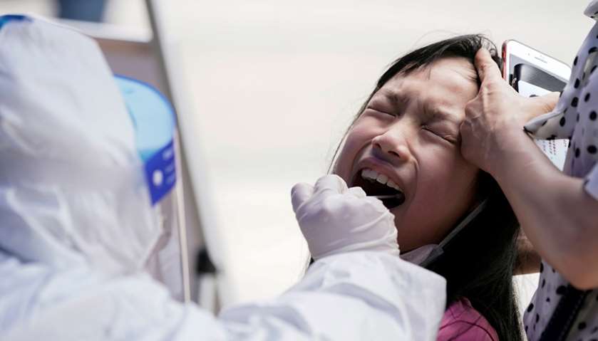A child reacts while undergoing nucleic acid testing in Wuhan