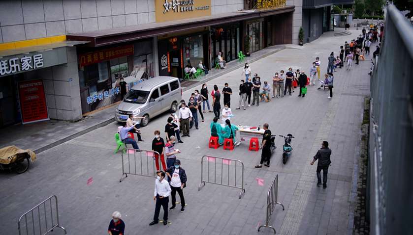 Residents wearing face masks queue for nucleic acid testings in Wuhan