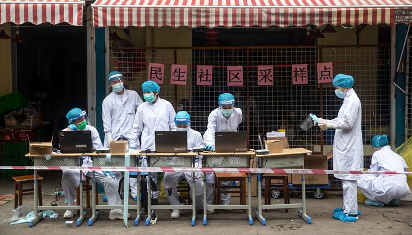 Medical workers arrange a COVID-19 coronavirus testing station in a street in Wuhan in China