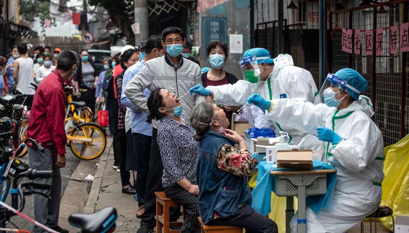 Medical workers take swab samples from residents to be tested for the coronavirus in a street in Wuh