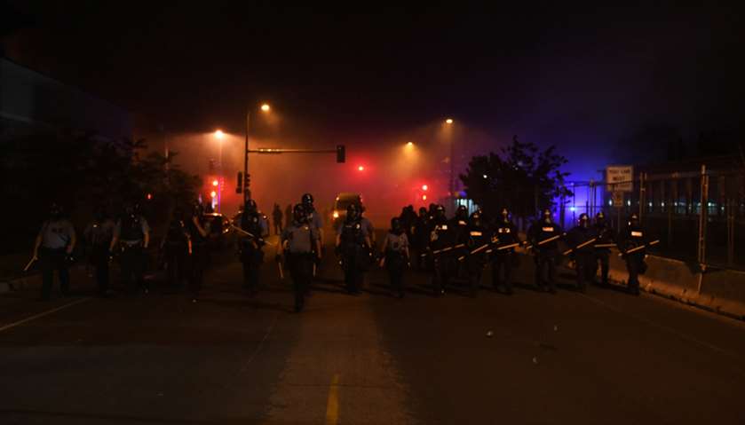 Riot police clear Nicollet Ave outside the fifth police precinct during the fourth day of protests