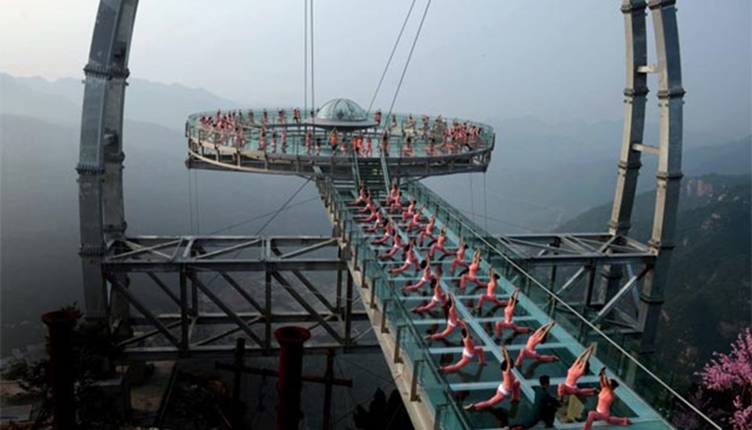 Chinese enthusiasts practise yoga at a glass sightseeing platform in the Shilinxia area in Beijing