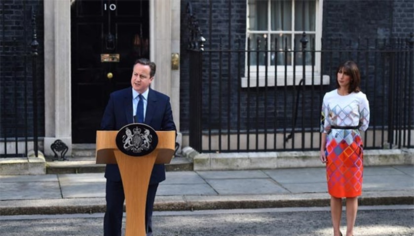 British Prime Minister David Cameron speaks to the press flanked by his wife Samantha in London
