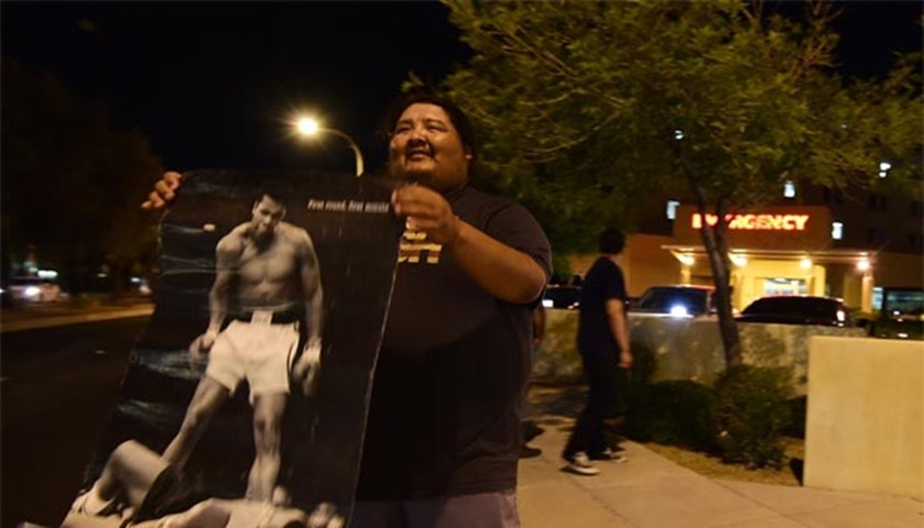 A man holds a poster of Muhammad Ali outside the hospital where Ali passed away, in Phoenix, Arizona