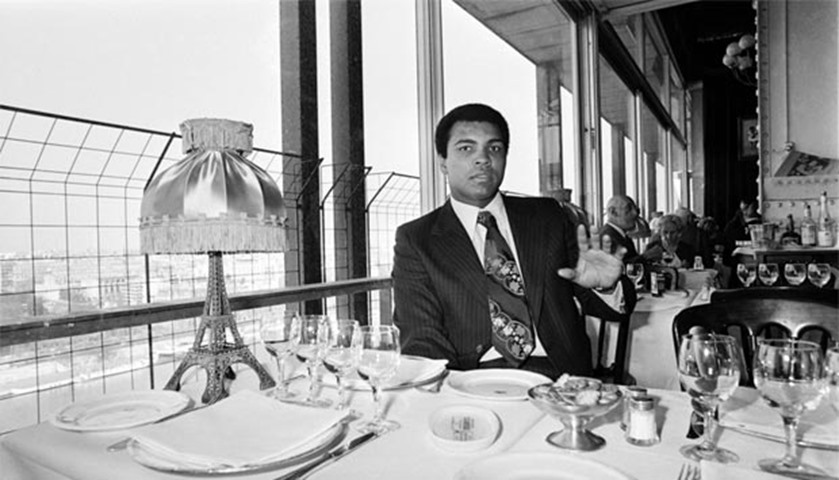 World heavyweight champion Muhammad Ali has lunch in the Eiffel Tower restaurant in Paris in 1976