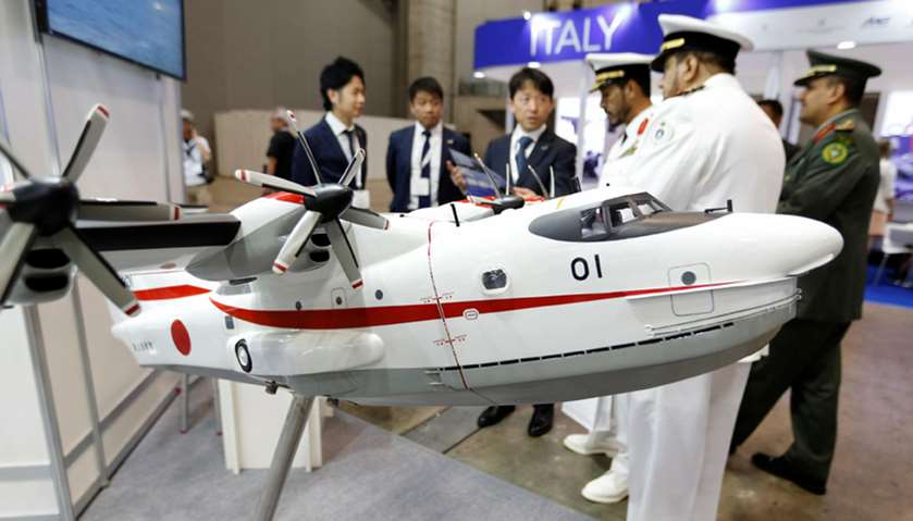 Military officials watch a model of Japan Maritime Self-Defense Forces US-2 search-and-rescue amphib