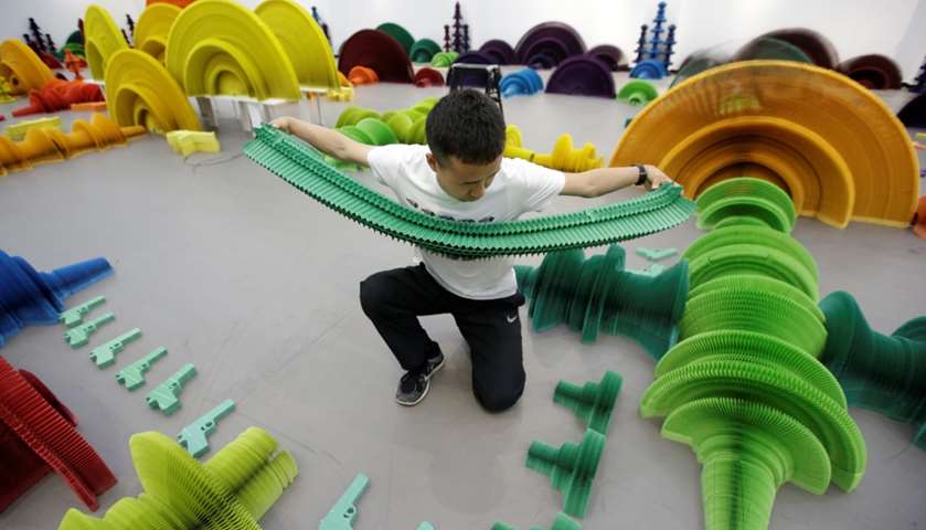 Li Hongbo prepares a paper sculpture in the shape of a handgun