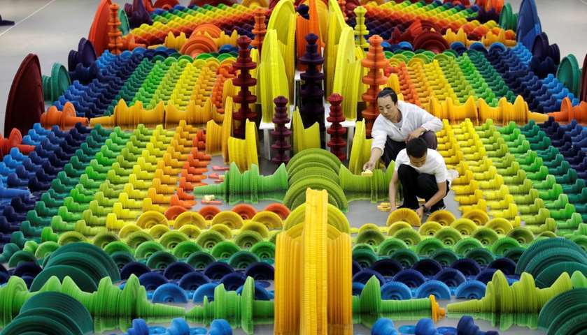 Li Hongbo (front) and his assistant set up his work \"Ocean of Flowers\"