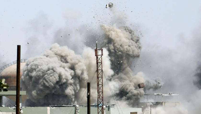 Debris fly as smoke rises after an artillery attack on the Islamic State militants\' positions by the