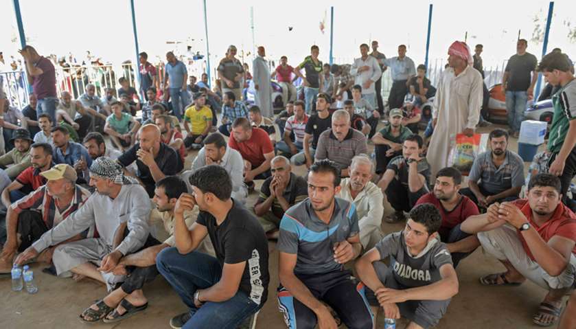 Displaced Iraqis gather at a temporary camp in the compound of the closed Nineveh International Hote