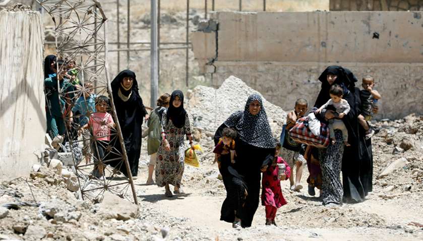 Displaced civilians walk towards the Iraqi Army positions after fleeing their homes due to clashes i