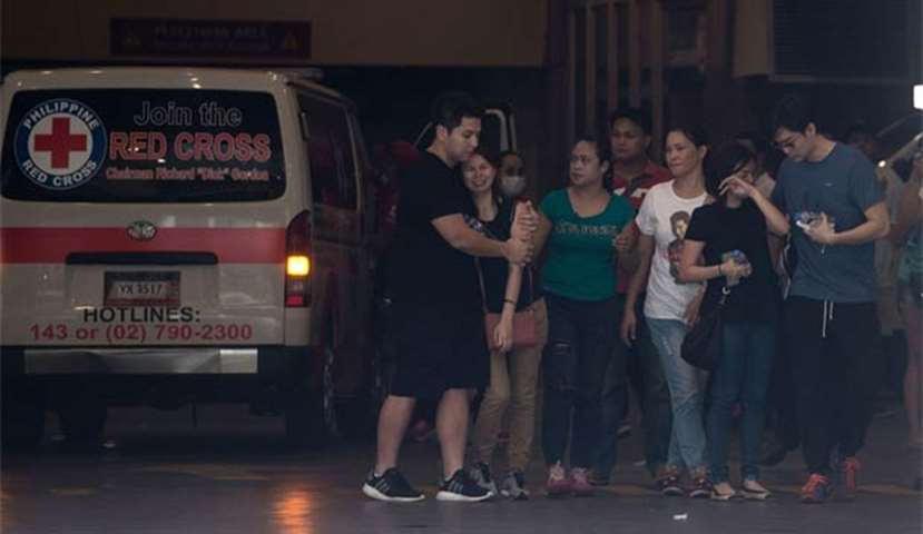 Relatives cry as they gather outside the Resorts World Hotel following a toxic blaze