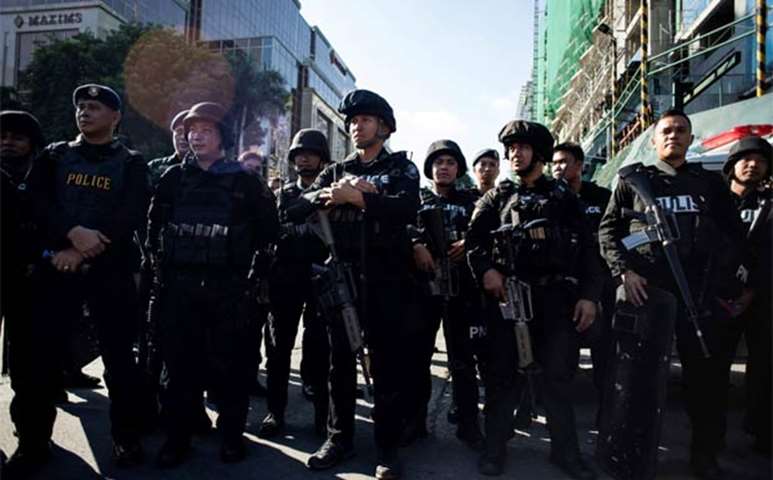 Philippines\' police officers stand in front of the Resorts World Hotel following an assault